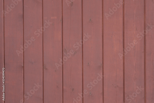 The wooden lining of the facade of the building is red, texture for the background.
