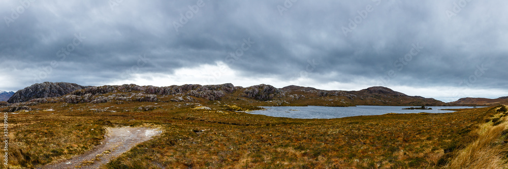 Mountain landscape with a small lake on a cloudy day in Scotland