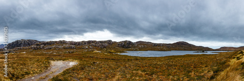 Mountain landscape with a small lake on a cloudy day in Scotland