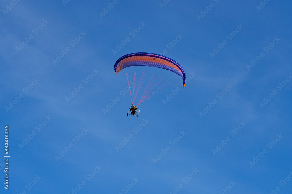 paraglider with a red-blue parachute flies paraglider with a red-blue parachute flies
