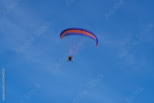 paraglider with a red-blue parachute flies