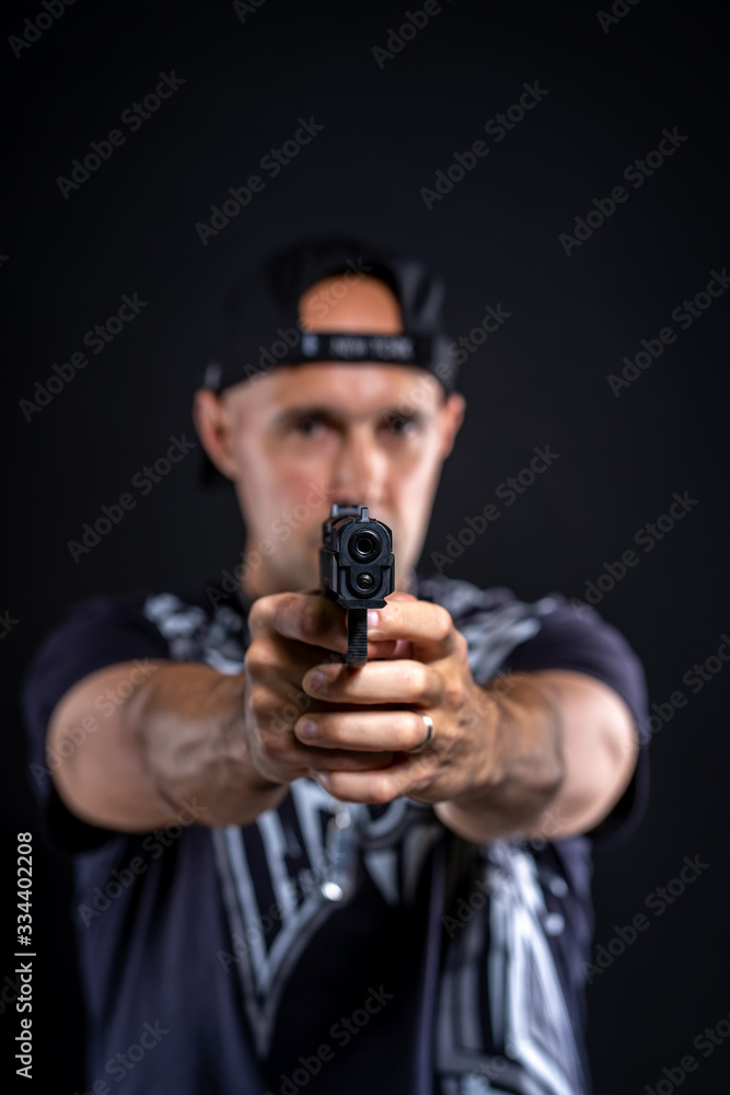 man pointing gun at object, portrait on black background man pointing gun at object, portrait on black background