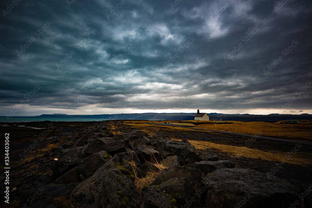 small church in an Icelandic landscape with moody clouds small church in an Icelandic landscape with moody clouds