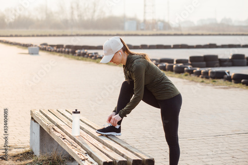 beautiful girl at morning workout outdoors in black leggings and with a bottle of water © Taras