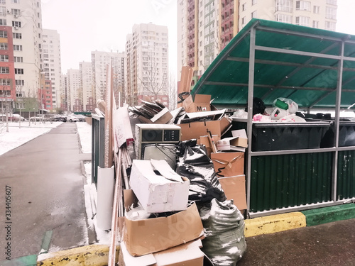 an overflowing metal dumpster in a residential complex