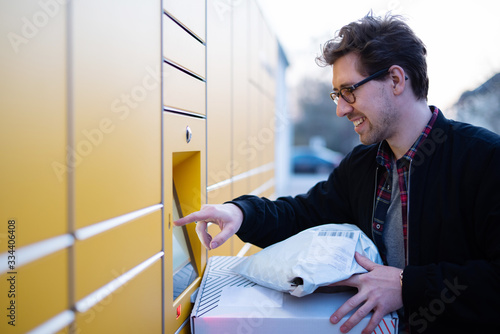 Ein Mann an einer Packstation, Pakete abholen und abgeben photo