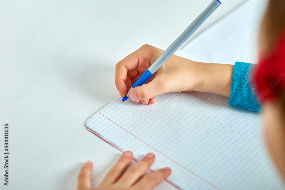 Schoolgirl doing homework, writing, studying lesson, coronavirus home school, social distance during quarantine, online education concept, home schooler. Stay at home, stay safe. Schoolgirl doing homework, writing, studying lesson, coronavirus home school, social distance during quarantine, online education concept, home schooler. Stay at home, stay safe.