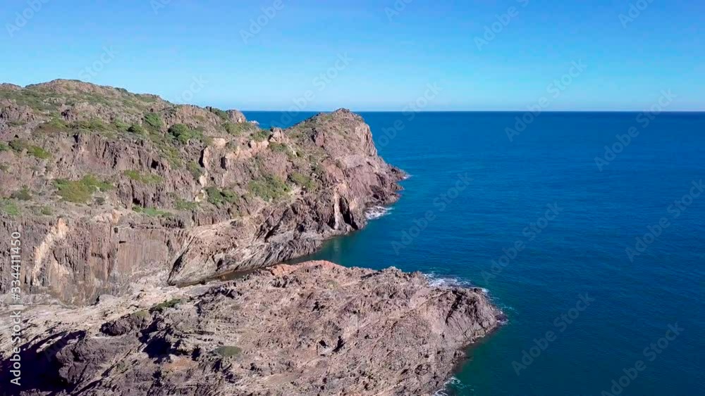 Aerial view of lighthouse on Cap de Creus cape, beautiful sea coast with blue bays and boats standing in sparkling water. Drone shot of easternmost point of Catalonia on background of scenic seascape Aerial view of lighthouse on Cap de Creus cape, beautiful sea coast with blue bays and boats standing in sparkling water. Drone shot of easternmost point of Catalonia on background of scenic seascape