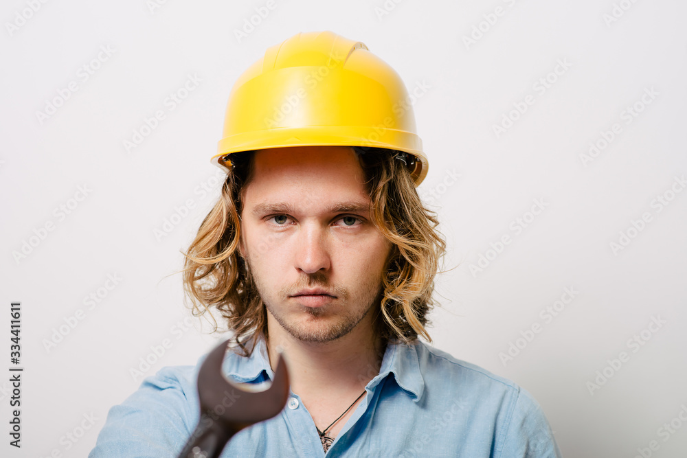 Portrait of young handyman holding a wrench Portrait of young handyman holding a wrench