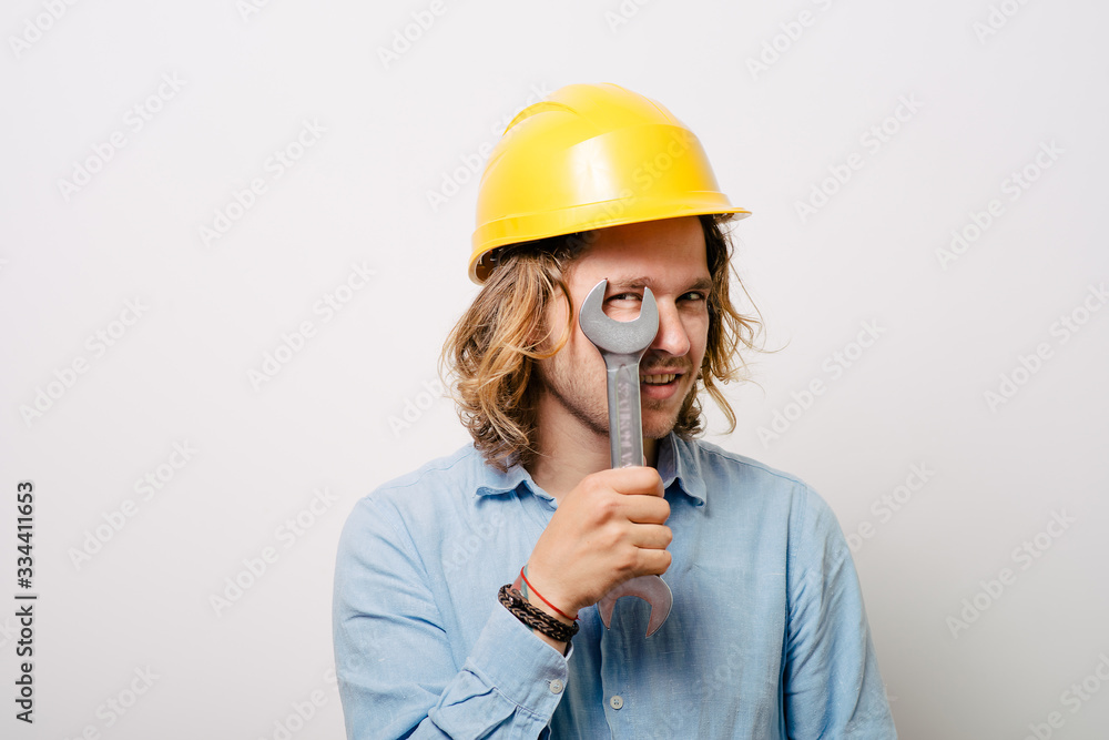 Portrait of young handyman holding a wrench Portrait of young handyman holding a wrench