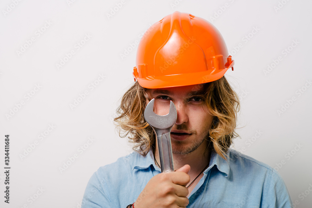 Portrait of young handyman holding a wrench Portrait of young handyman holding a wrench