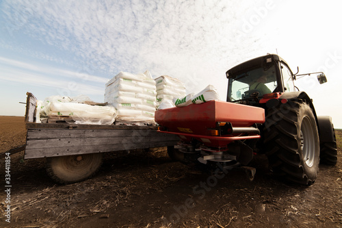 Tractor spreading artificial fertilizers in field © Dusan Kostic