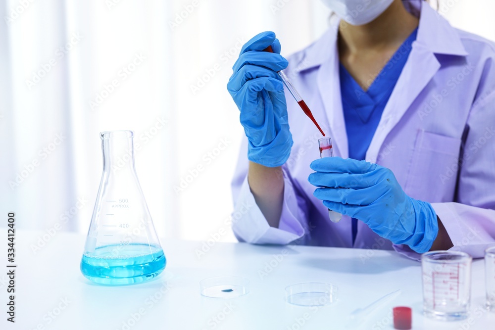 Scientist holding Coronavirus covid-19 infected blood sample tube DNA testing of the blood in the laboratory with blood sample collection tubes and syringe Coronavirus Covid-19 vaccine research. Scientist holding Coronavirus covid-19 infected blood sample tube DNA testing of the blood in the laboratory with blood sample collection tubes and syringe Coronavirus Covid-19 vaccine research.
