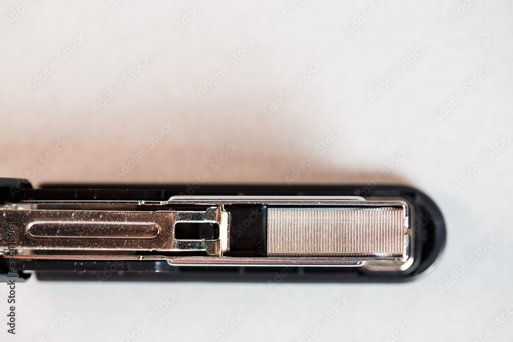 black stapler for fastening papers on a gray background