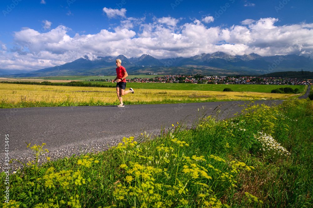 Athlete train under mountains, Morning mountains landscape in background