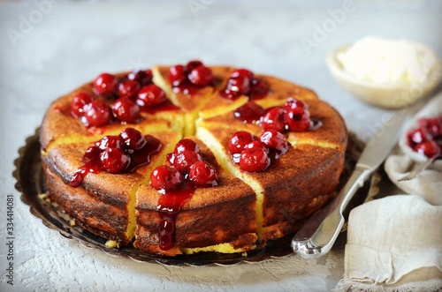 Cottage cheese casserole with cherry sauce on a plate on a gray background