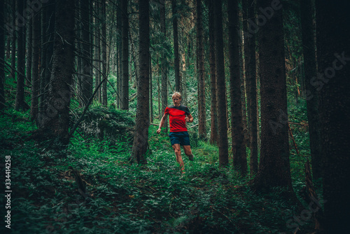 Sport in nature. Male runner in green beautiful forest