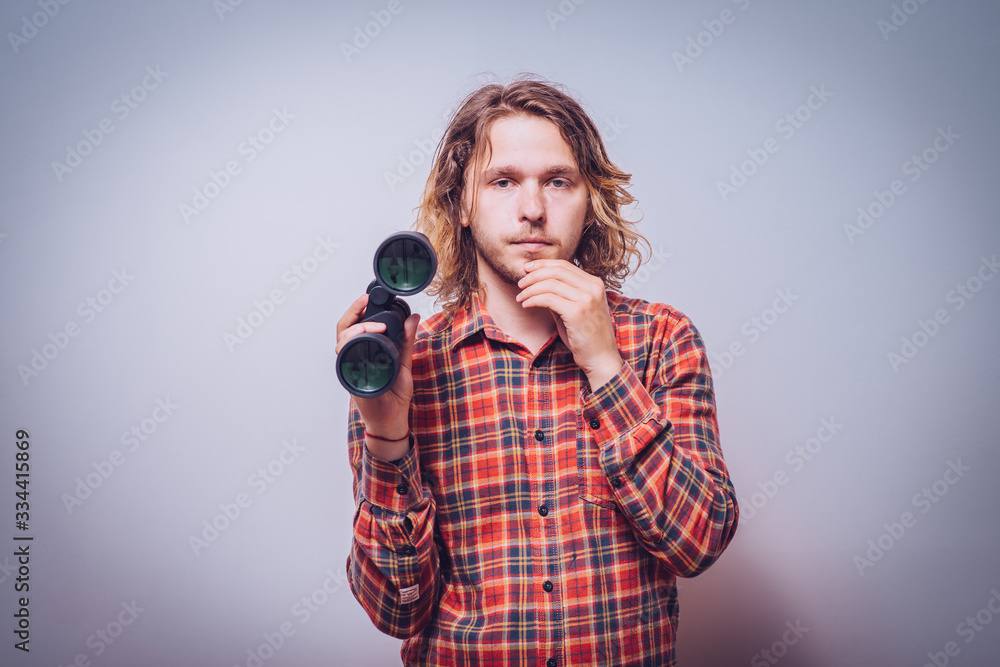 Obraz premium man with binoculars. gray background