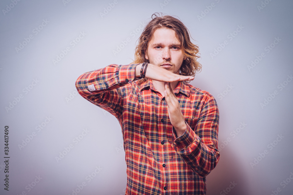 A man shows the hands stop timeout. On a gray background. A man shows the hands stop timeout. On a gray background.