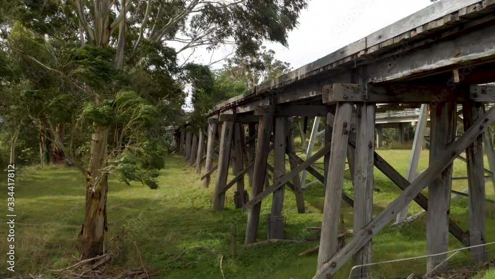 aerial shot moving forward to an old railway bridge among gum trees. aerial shot moving forward to an old railway bridge among gum trees.