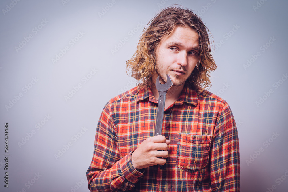 Portrait of young handyman holding a wrench Portrait of young handyman holding a wrench