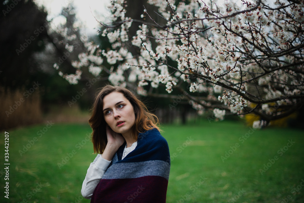 Beautiful young girl is resting and enjoying spring in the spring park Beautiful young girl is resting and enjoying spring in the spring park