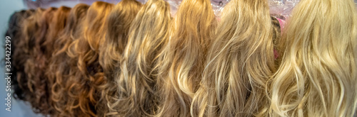 different colored and different types of wigs displayed in the shop
