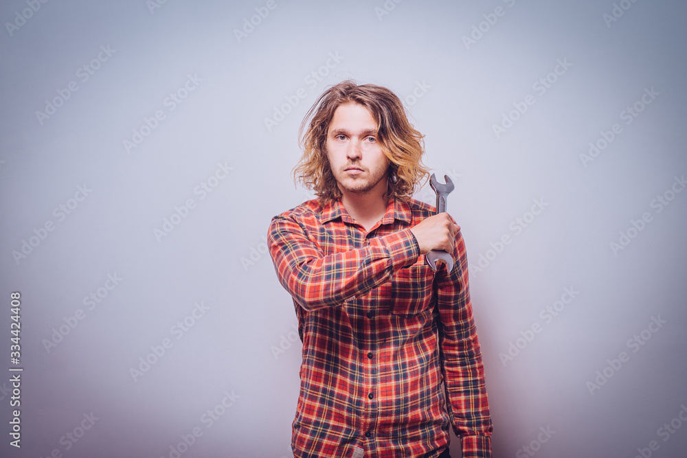 Portrait of young handyman holding a wrench Portrait of young handyman holding a wrench