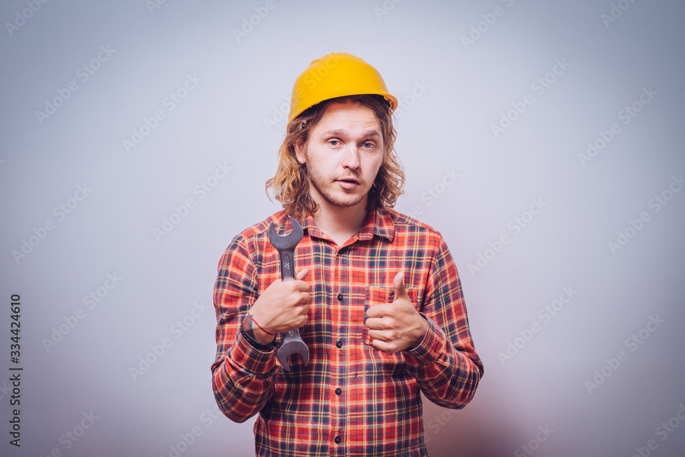 Portrait of young handyman holding a wrench Portrait of young handyman holding a wrench
