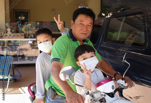 Grandfather took two grandsons go to market and wear white masks protection