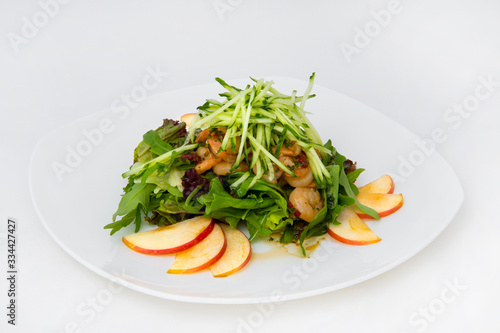 Salad of king prawns, sorrel, lettuce, cucumbers, lemon balm. The salad is seasoned with olive oil and lemon juice. Garnished with thinly sliced apple