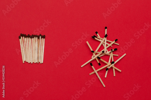 Used and unused matches on red background. Order and chaos, dead or  alive, healthy and sick, fresh and rotten, good and bad, free and captive, self-isolation, quarantine concept.
