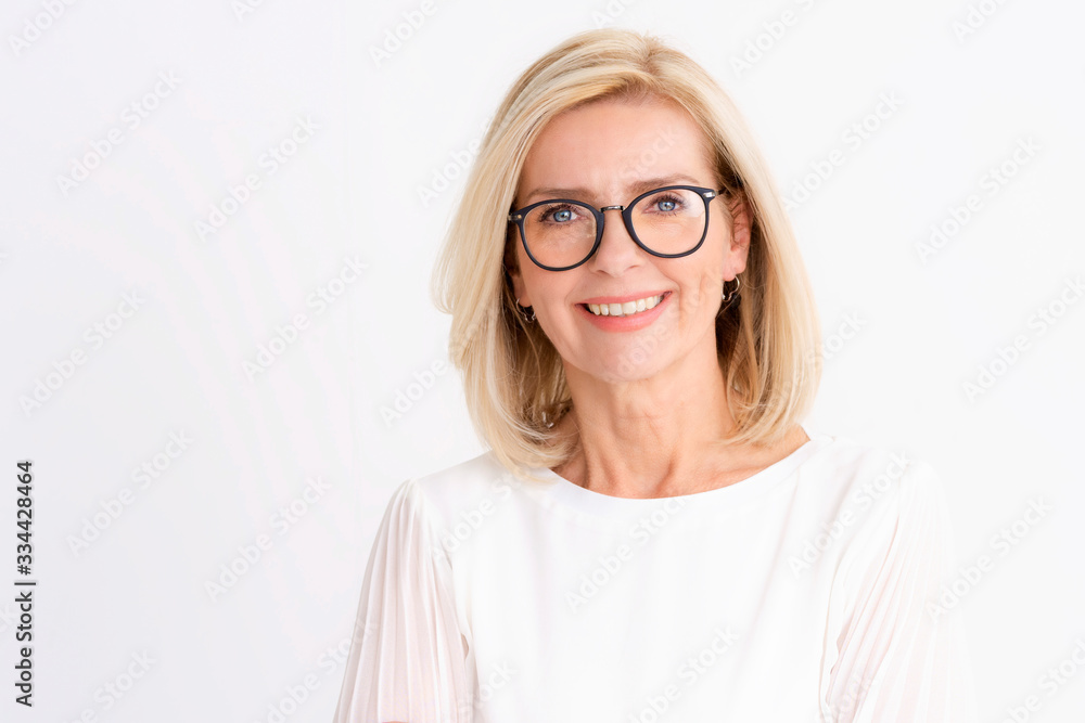 Attractive senior woman studio portrait while looking at camera and smiling