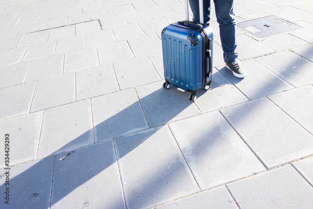 people dragging a travel suitcase