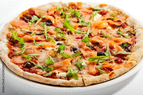 Sliced pizza with salmon, calamata olives and sun dried tomatoes