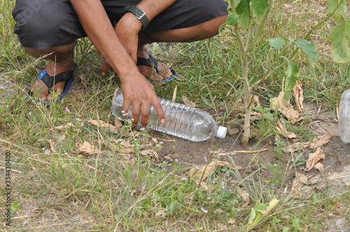 pouring water to a plant with recycle bottle technology