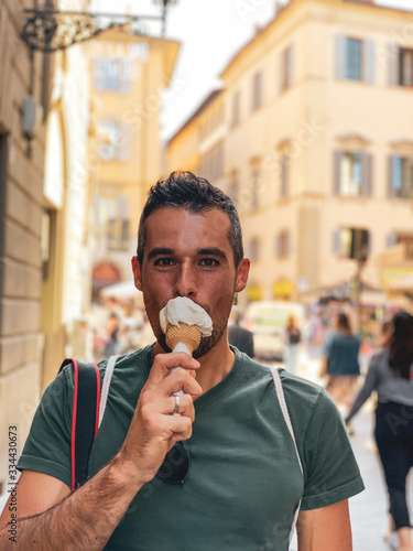 Tourist isst ein Eis in belebter italienischer Stadt vor der Corona Pandemie