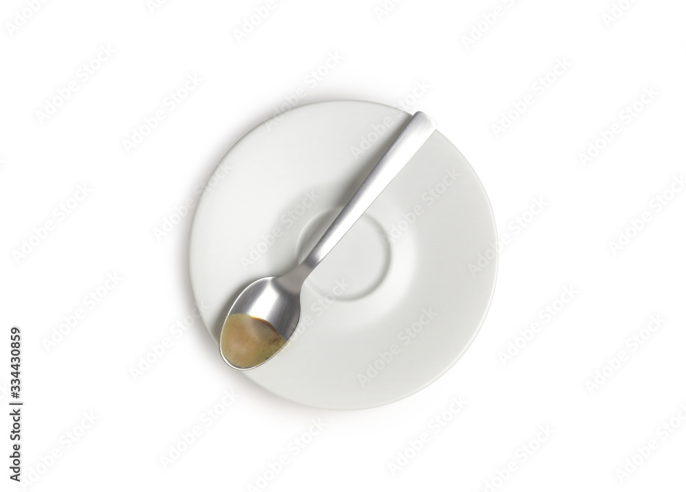 Saucer and coffee spoon, isolated on white background, top view