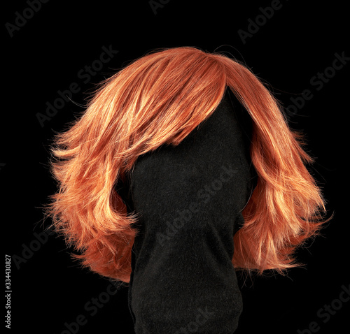 Red hair wig isolated on black background