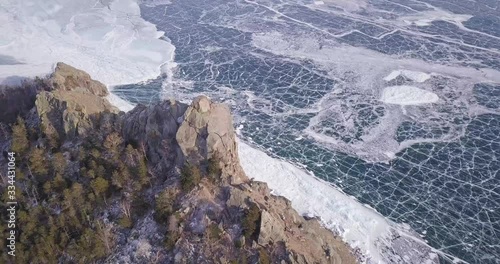 Frozen lake Deep blue ice, hummocks, mountain cracks. Beautiful winter landscape with transparent smooth ice.