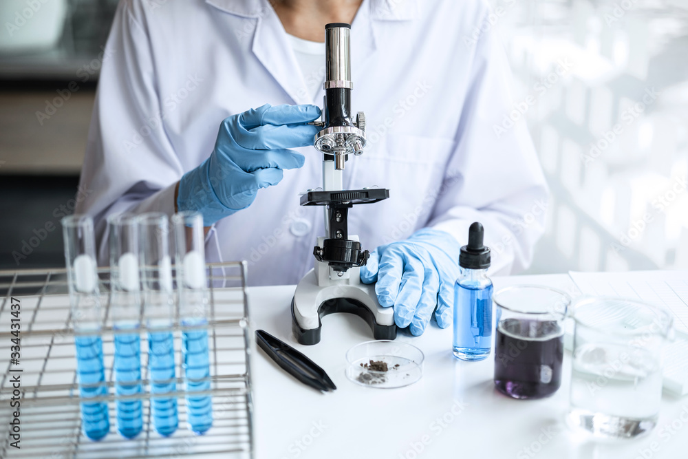 Biochemistry laboratory research, Chemist is analyzing sample in laboratory with Microscope equipment and science experiments glassware containing chemical liquid Biochemistry laboratory research, Chemist is analyzing sample in laboratory with Microscope equipment and science experiments glassware containing chemical liquid
