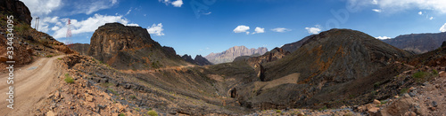 Mountain and valley view along Wadi Sahtan road and snake canyon in Al Hajir mountains between Nizwa and Mascat in Oman photo