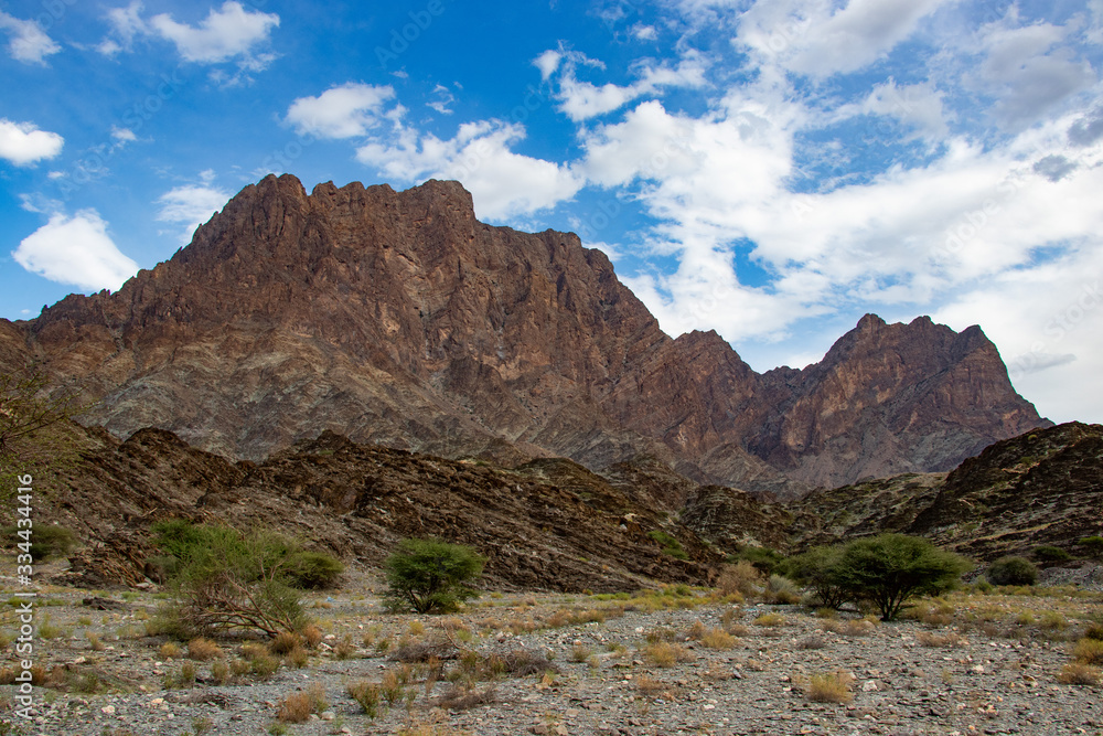 Fototapeta premium Mountain and valley view along Wadi Sahtan road and snake canyon in Al Hajir mountains between Nizwa and Mascat in Oman