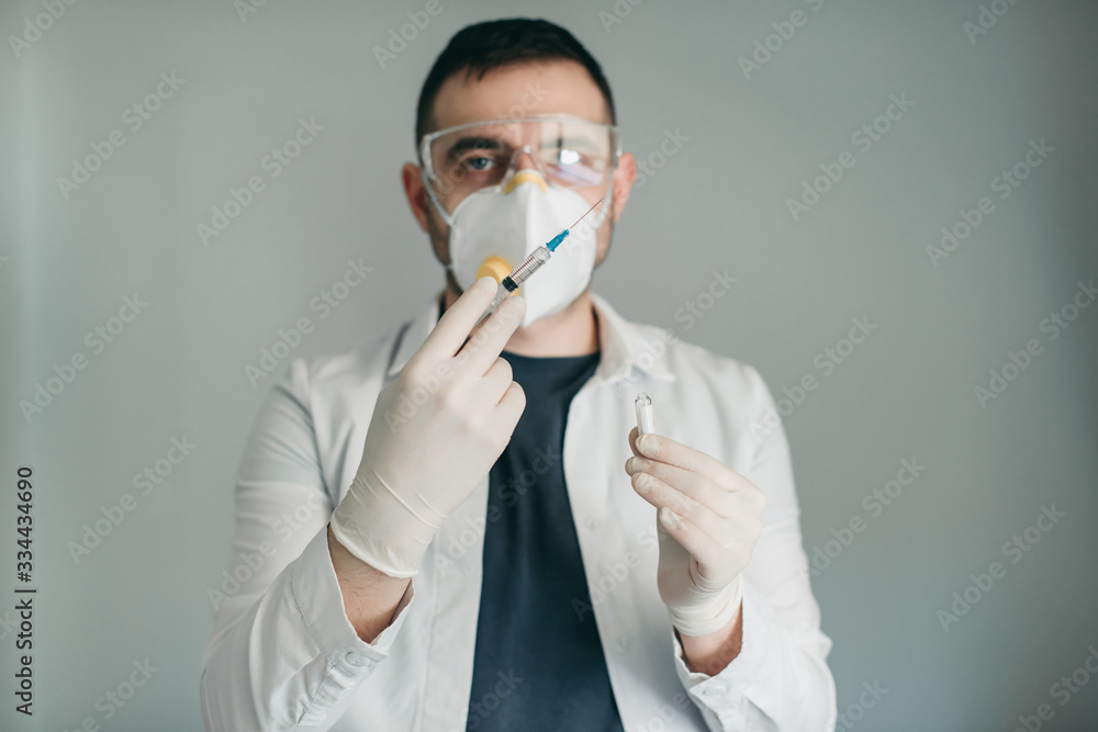 brunette man medical doctor scientist in glasses and protective mask with syringe vaccine in hands in hospital, laboratory. Medication for coronavirus illness, infection, quarantine, surgical bandage brunette man medical doctor scientist in glasses and protective mask with syringe vaccine in hands in hospital, laboratory. Medication for coronavirus illness, infection, quarantine, surgical bandage