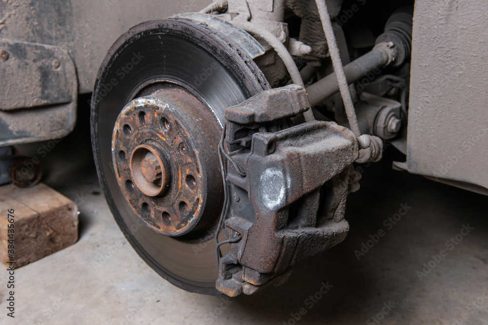 An old worn-out brake disc requiring replacement. Close-up with the wheel removed.