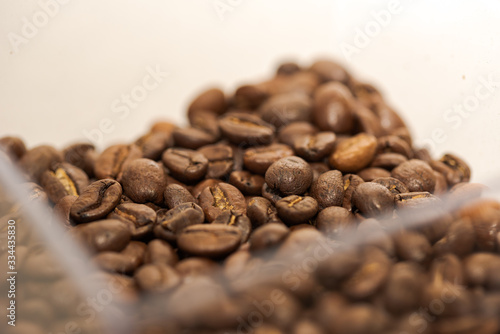 High quality roasted coffee beans lying in coffee grinder tank
