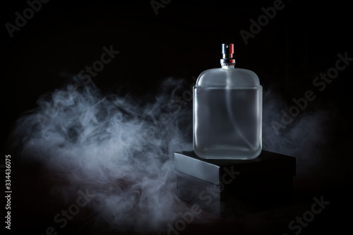 Men's perfume in smoke on a black background