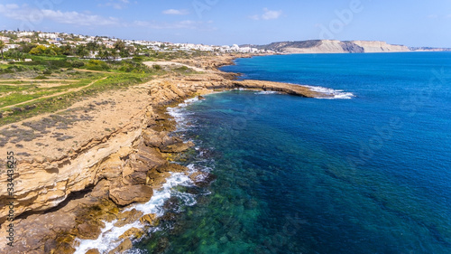 Aerial view of the stone shores of southern Portuguese beaches, crystal water, the village of Luz.