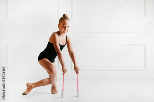 Cute gymnast girl posing with mace isolated on white