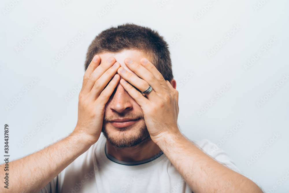 Man closes eyes with her hands